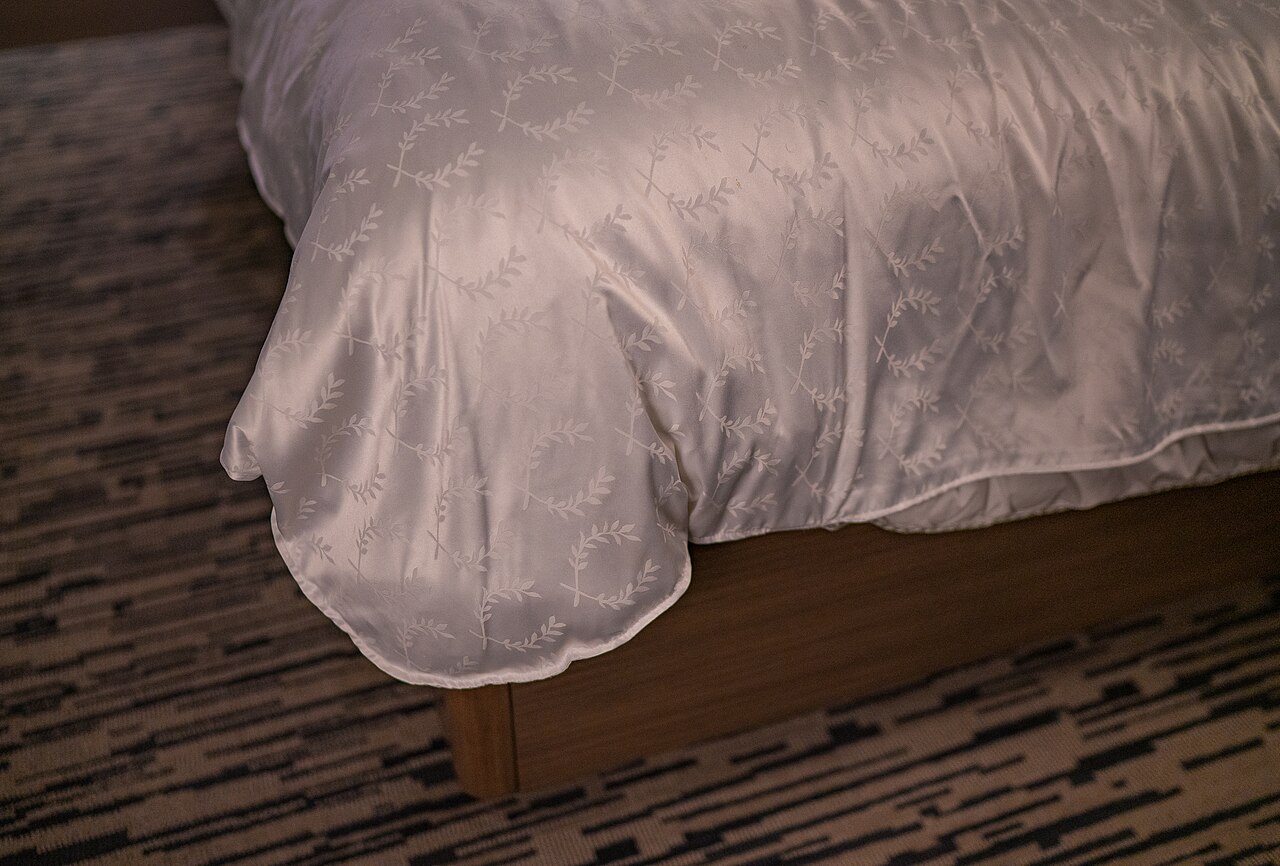 Opgemaakt bed in een hotelkamer, illustratief archiefbeeld.