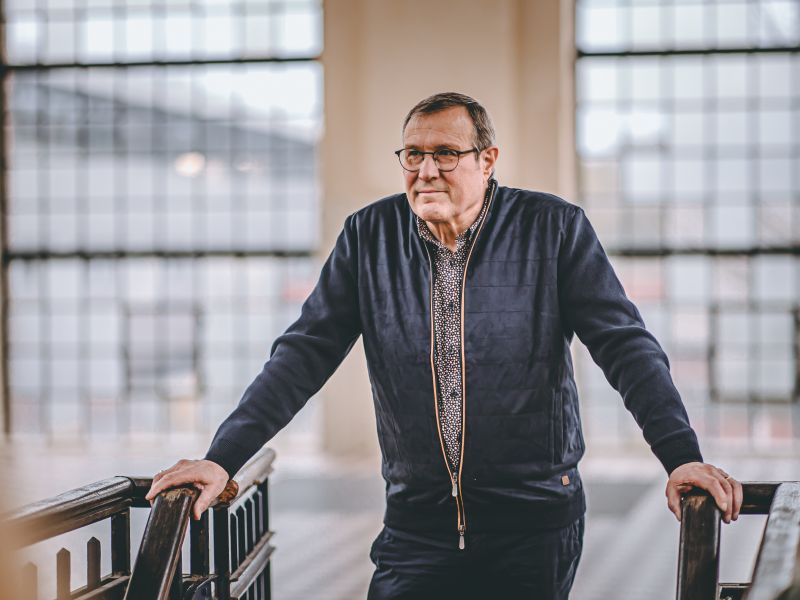 Portret van Jos Thijssen, staand bij een balustrade.