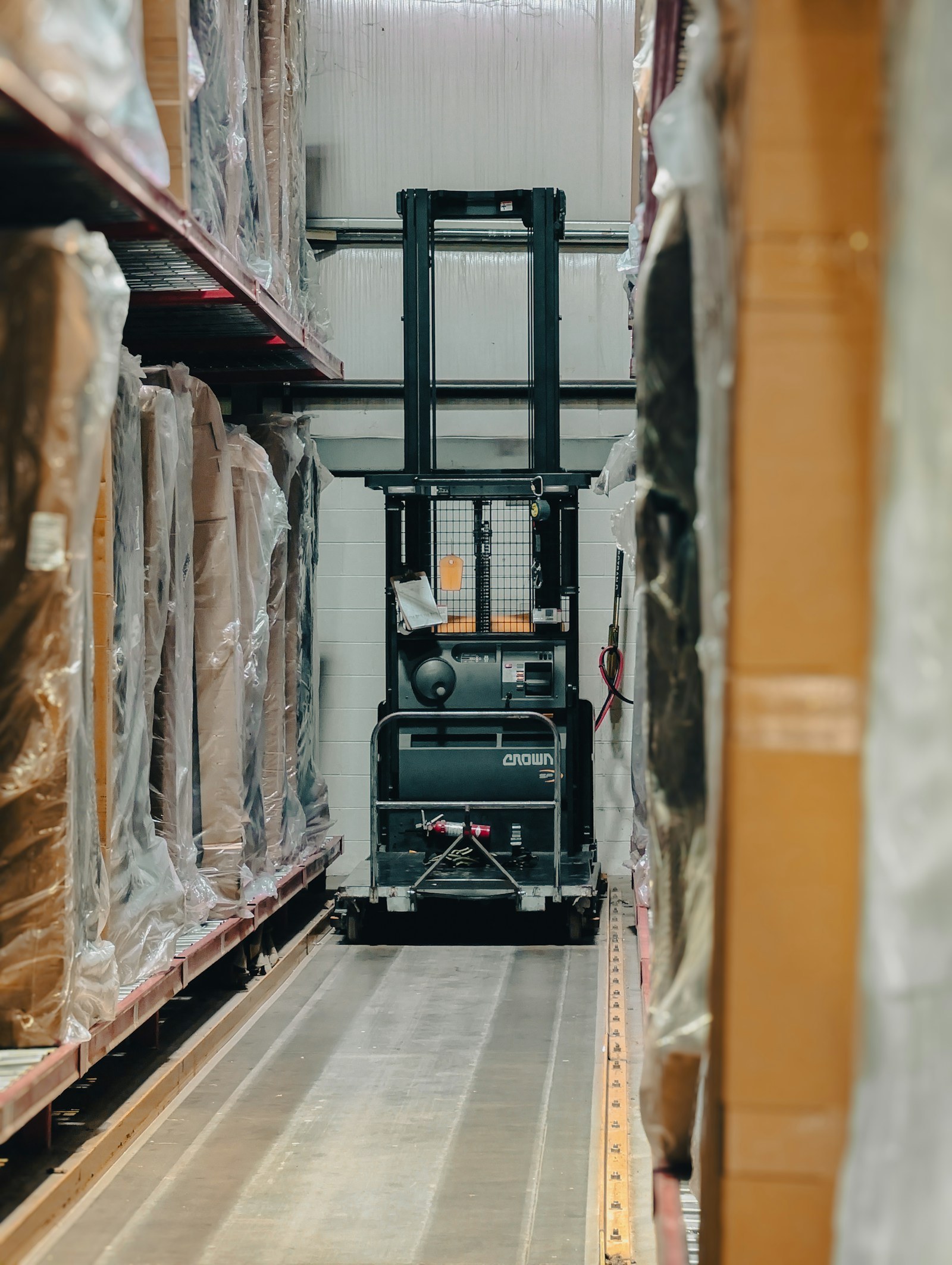 Palletstellingen met een magazijntruck in een smalle gang.