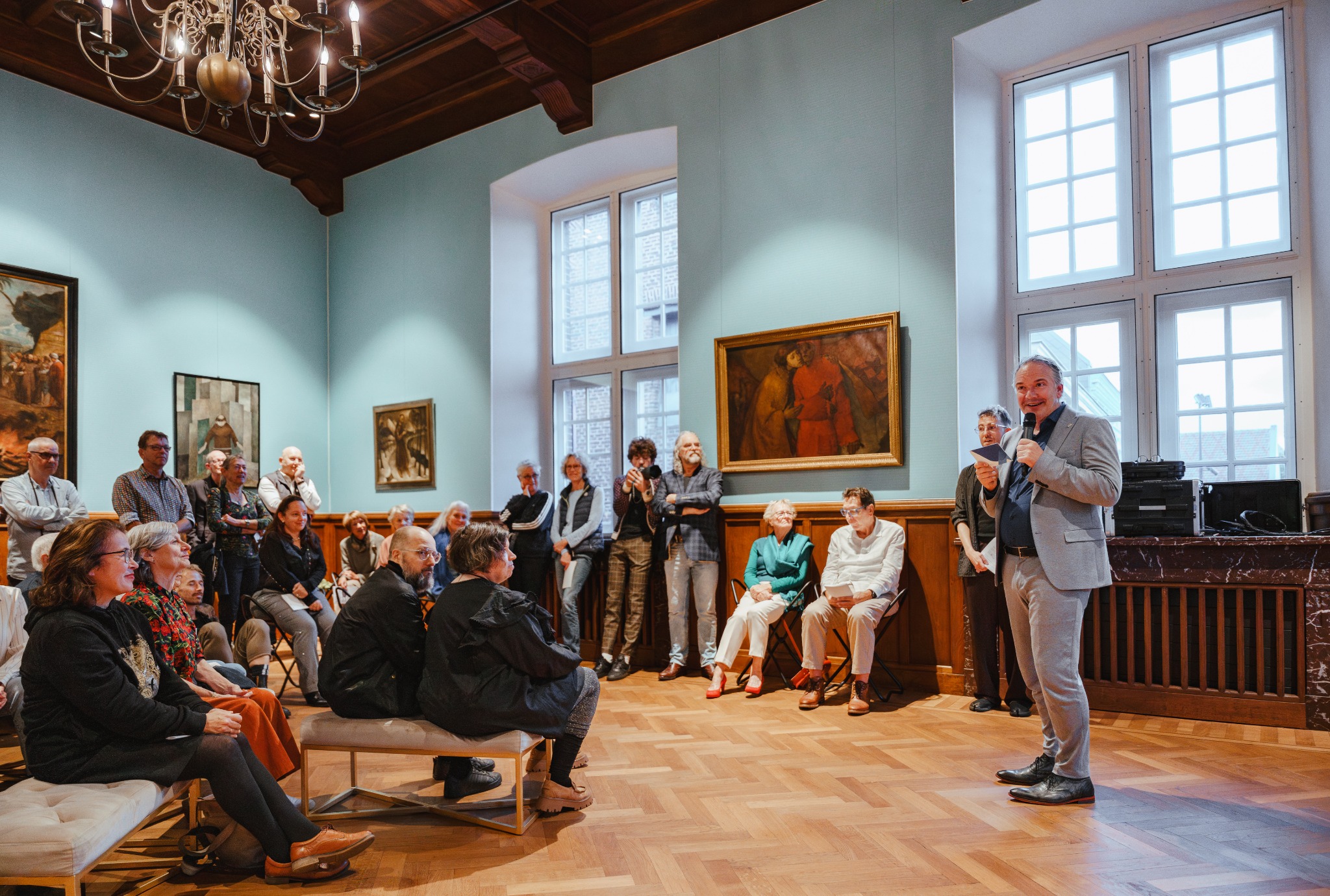 Wethouder Peter Mols spreekt bezoekers toe tijdens de opening van de tentoonstelling in Museum W.